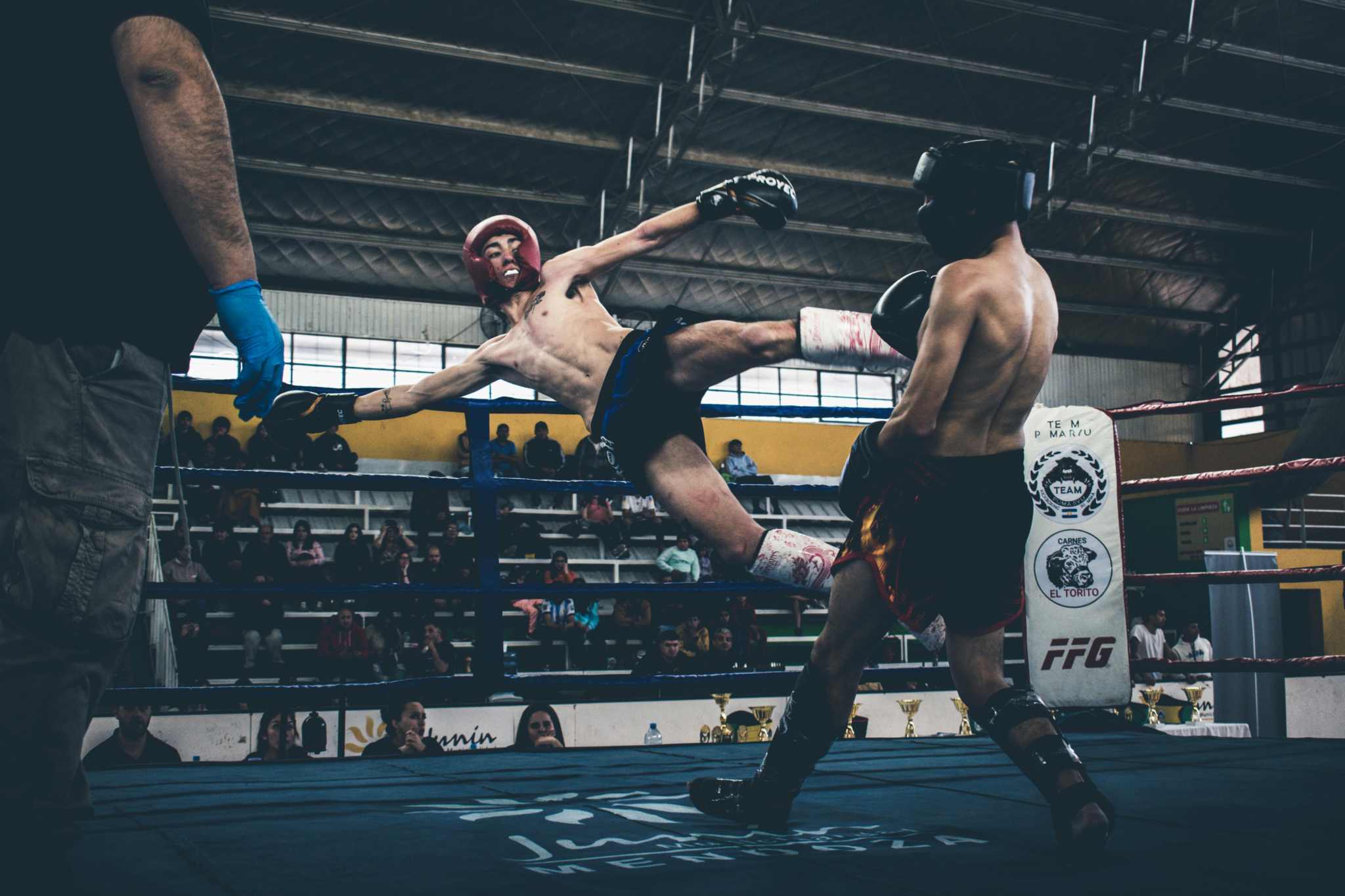 combat de muay thai sur un ring avec des protections