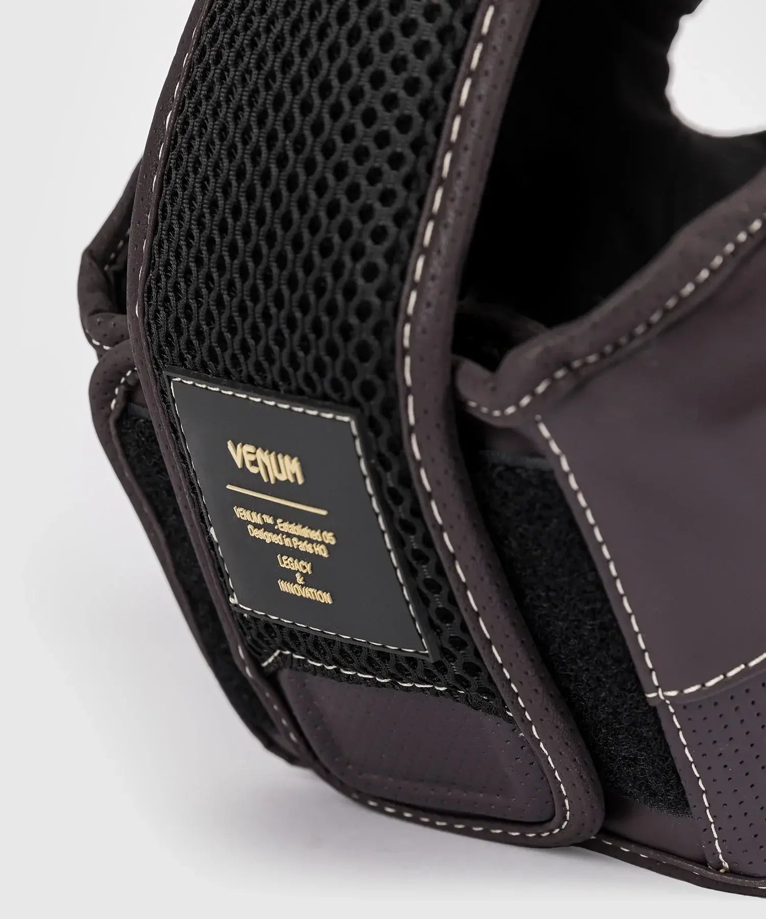 Close-up of Casque Venum Impact Evo boxing headgear in chocolate color showing premium Skintex leather and mesh padding.