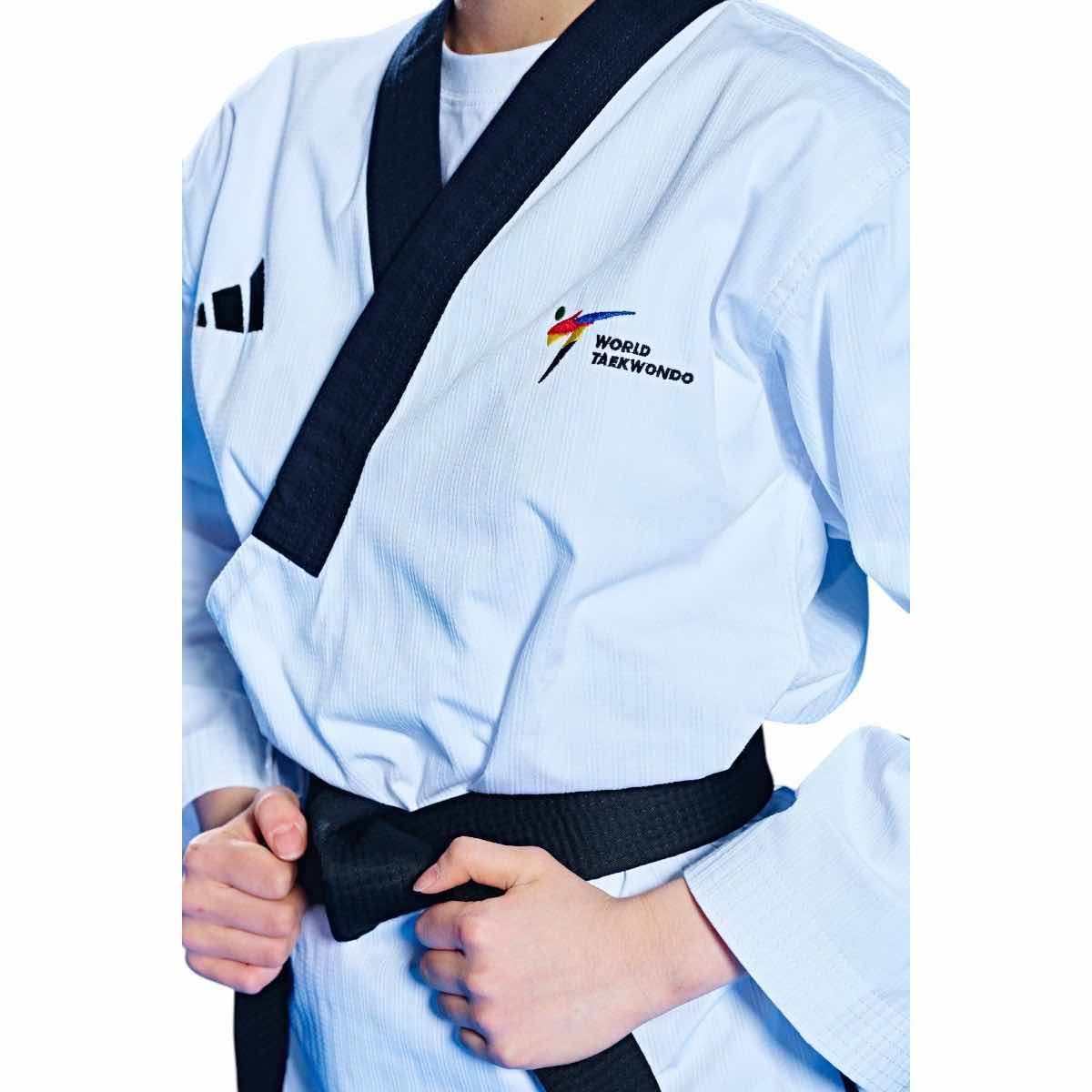 Female Dobok Taekwondo Poomsae uniform by adidas with black collar and World Taekwondo logo.
