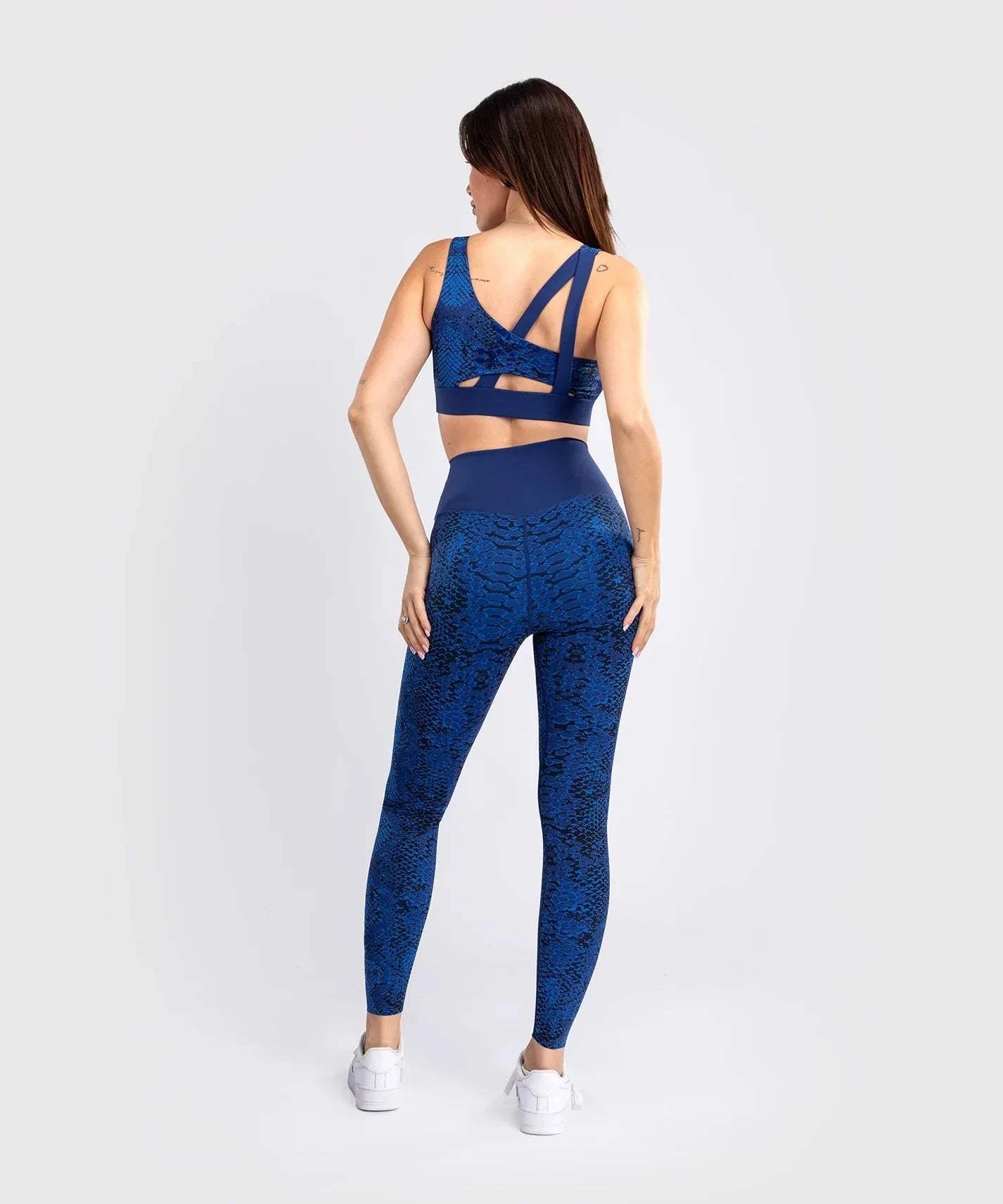 Woman wearing ultramarine Venum Amazonia long leggings with snake skin pattern from the back