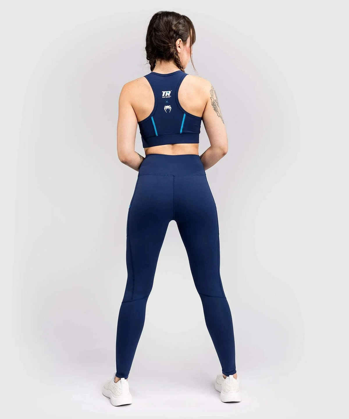 Woman wearing navy blue compressive long leggings from Venum x Top Rank athletic collection, shown from the back