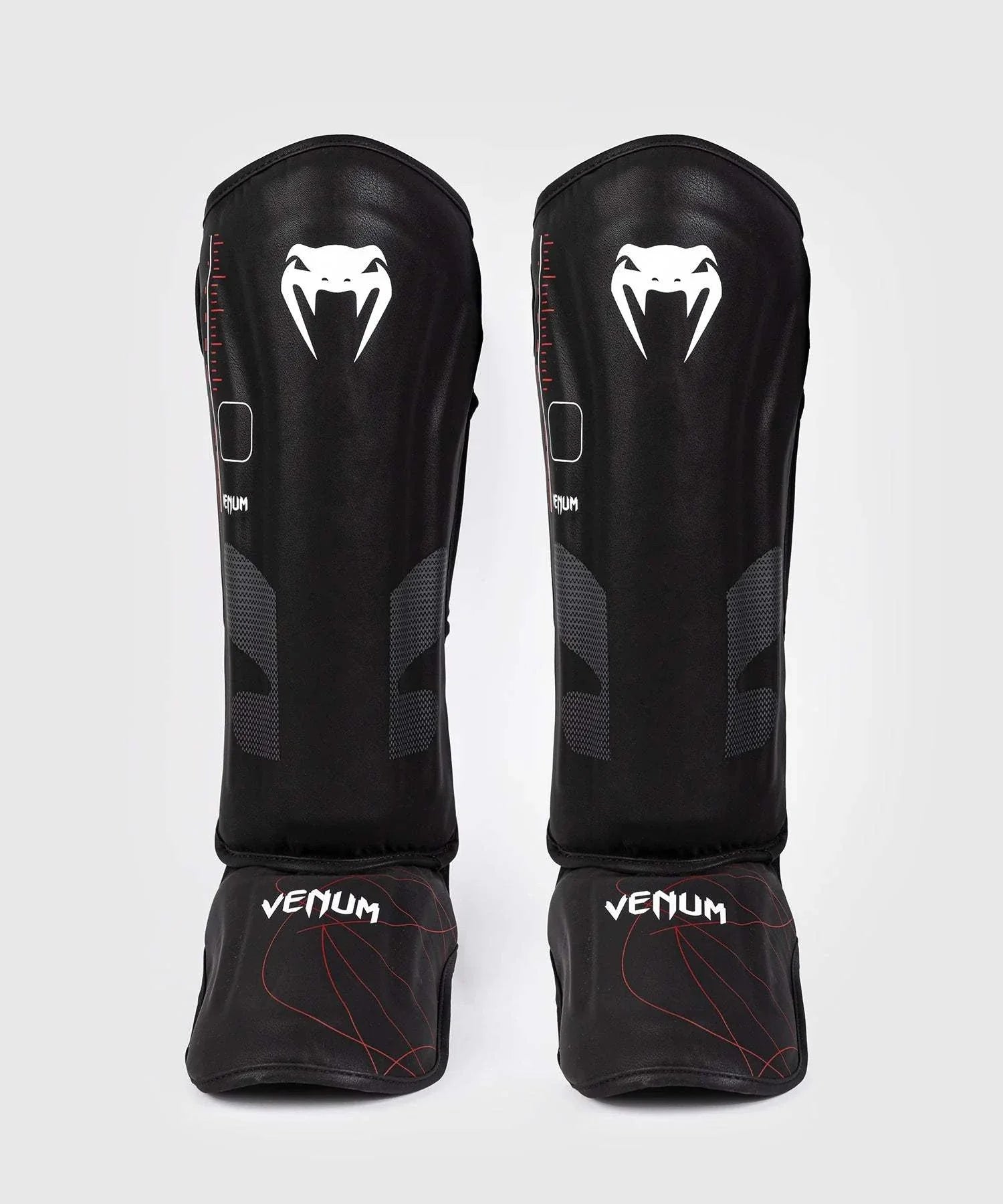 Black and red Venum Tactical XT shin and foot guards with multi-density foam and velcro straps for shock absorption and secure fit.