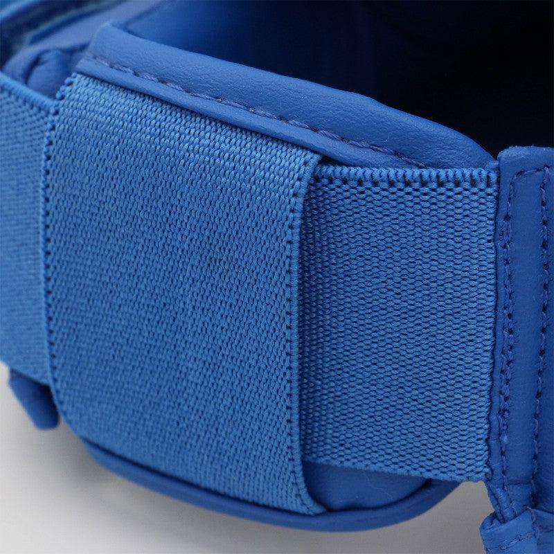 Close-up of blue Adidas WKF-certified karate shin and foot protector strap with secure elastic and Velcro fastening.