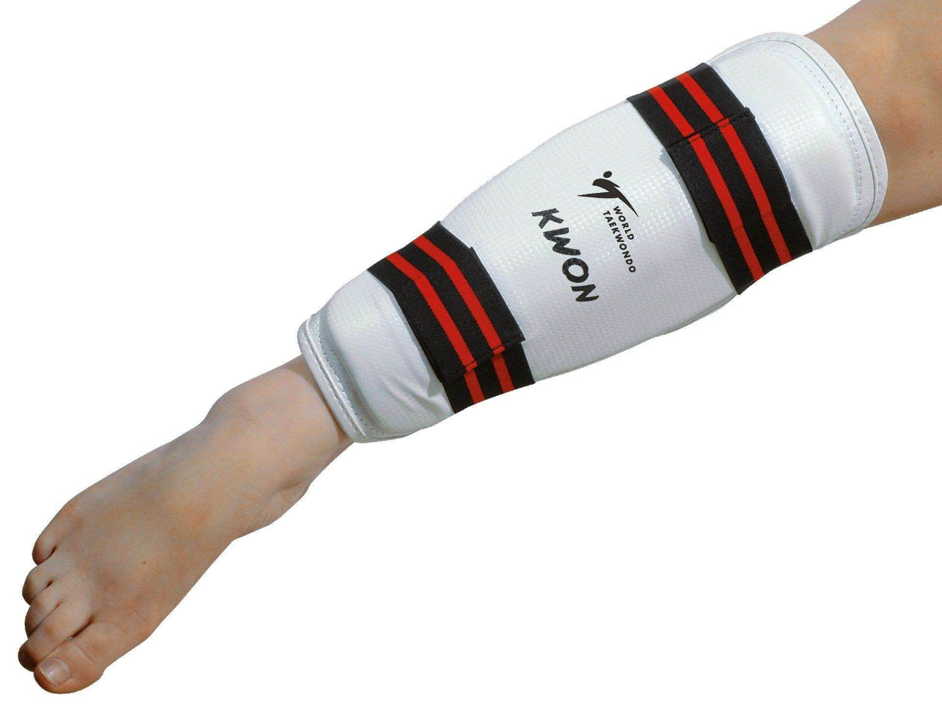 Kwon Protege-tibias white and black Taekwondo shin guards with adjustable straps and PU exterior for martial arts protection