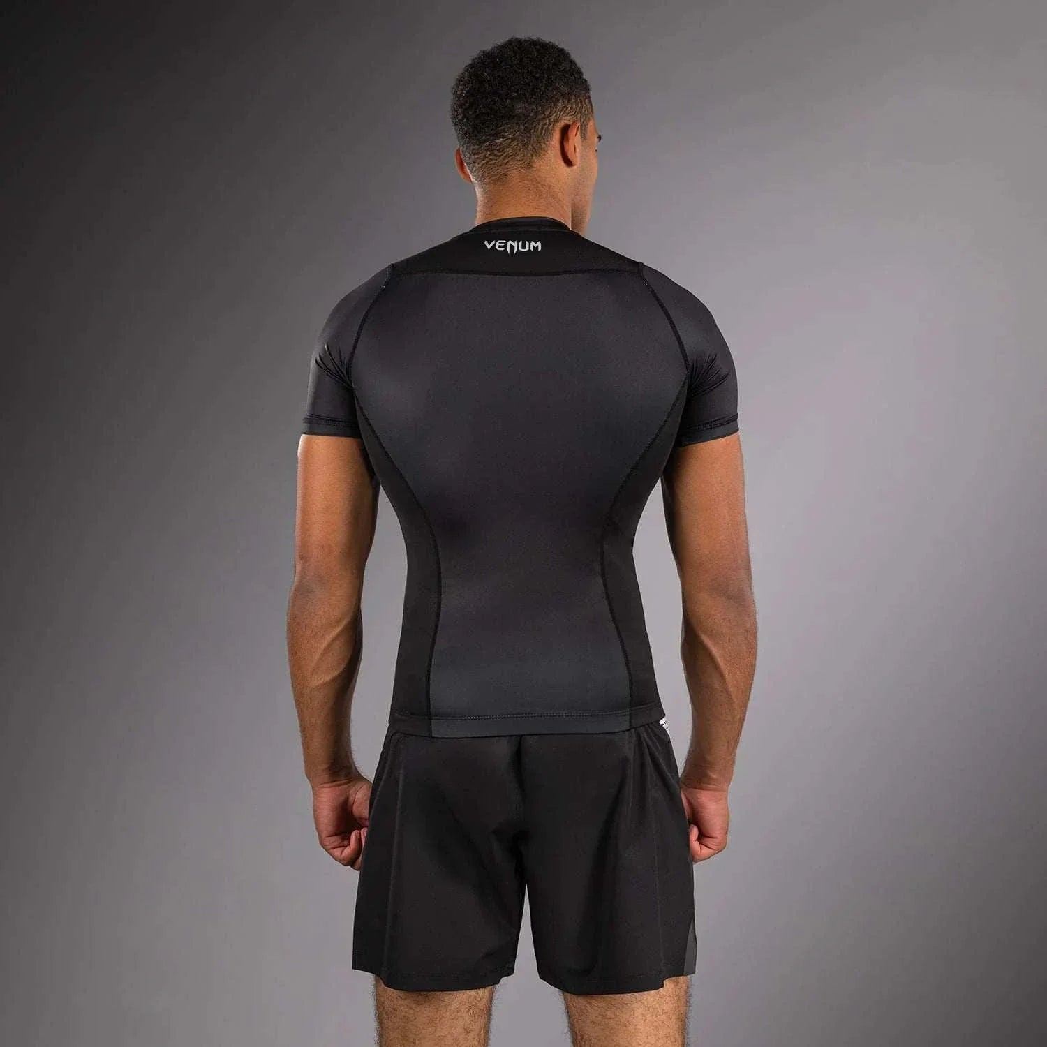 Rashguard Venum No Gi noir et blanc pour Jiu-Jitsu Brésilien No-Gi et MMA avec compression haute performance et coutures renforcées.
