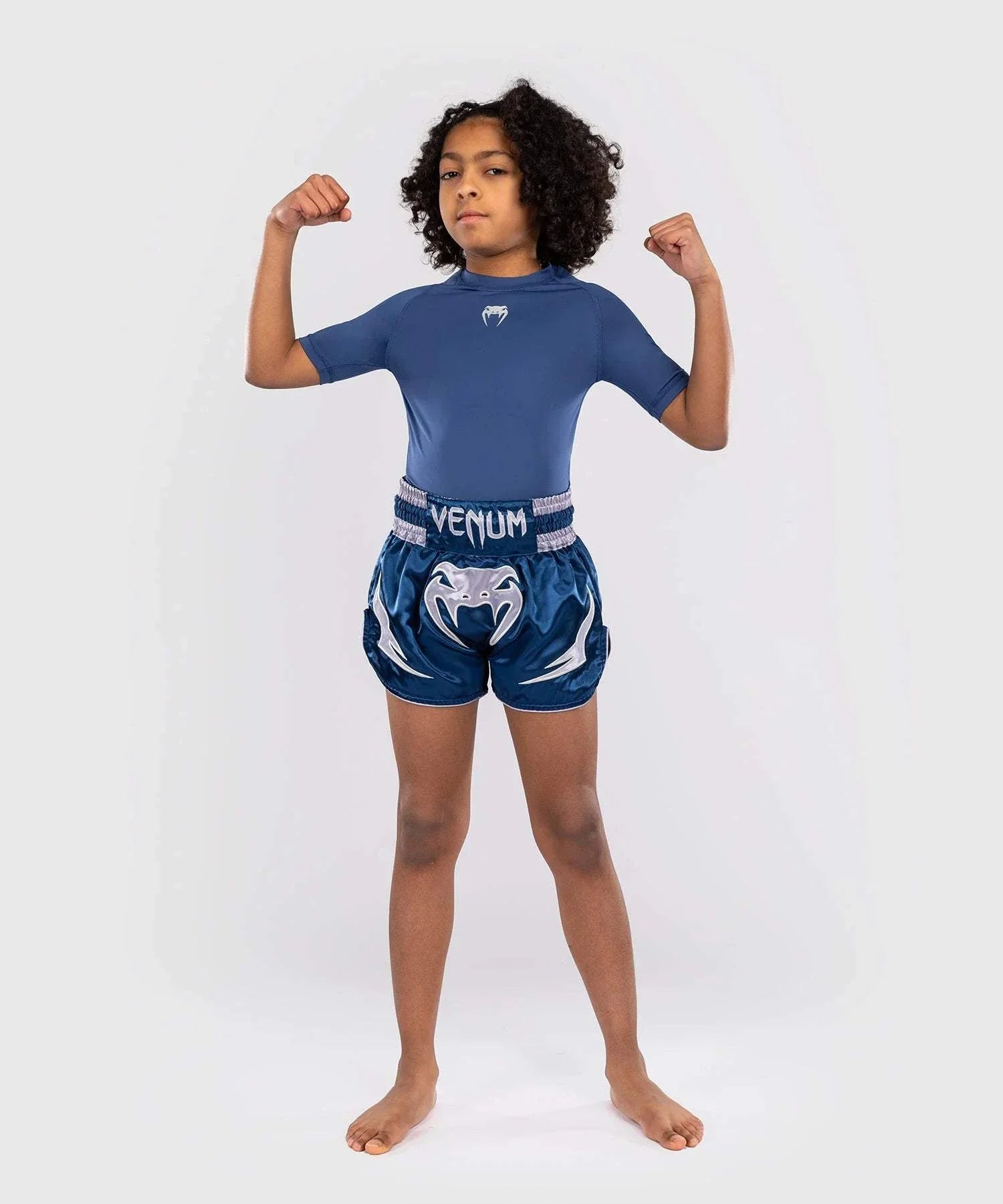 Young athlete wearing blue Short Muay Thai Venum Inferno with satin finish and deep side slits for mobility