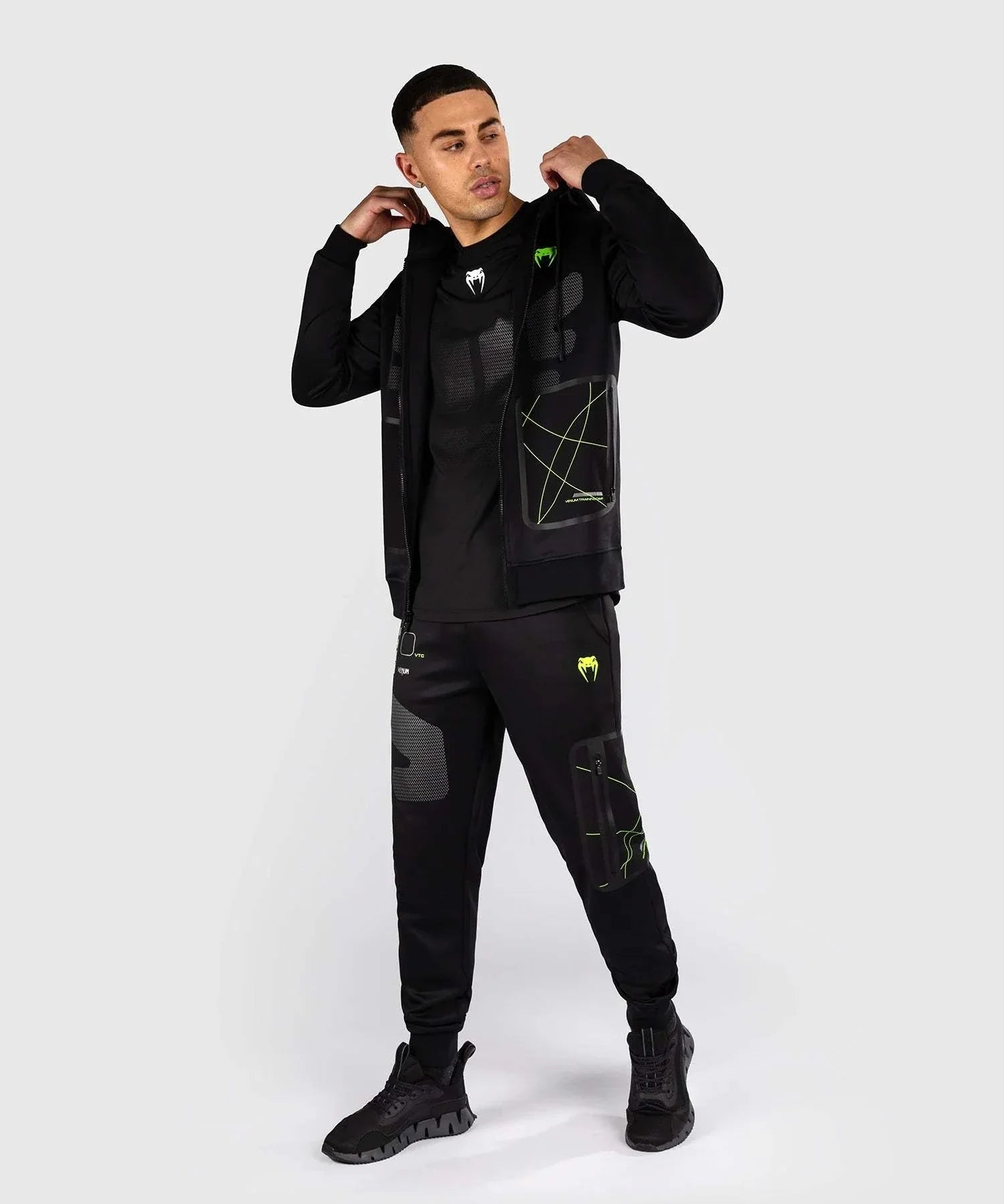 Black and neon green Venum Training Camp 4.0 zip-up hoodie with breathable Dry Tech fabric and adjustable hood, worn with matching pants