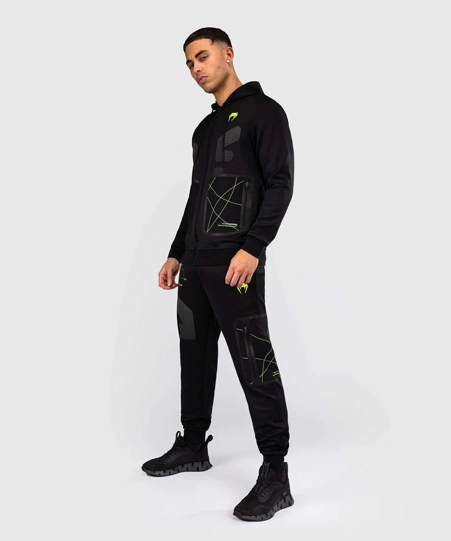 Black and neon green Venum Training Camp 4.0 zip-up hoodie with adjustable hood and breathable Dry Tech fabric worn by a male model