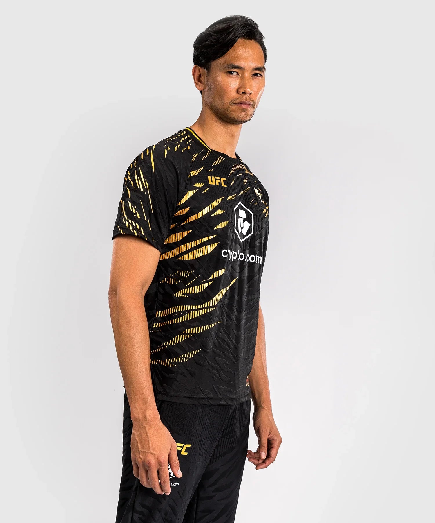Men wearing black and gold UFC Fusion par Venum Dry-Tech performance T-shirt with short sleeves and breathable fabric