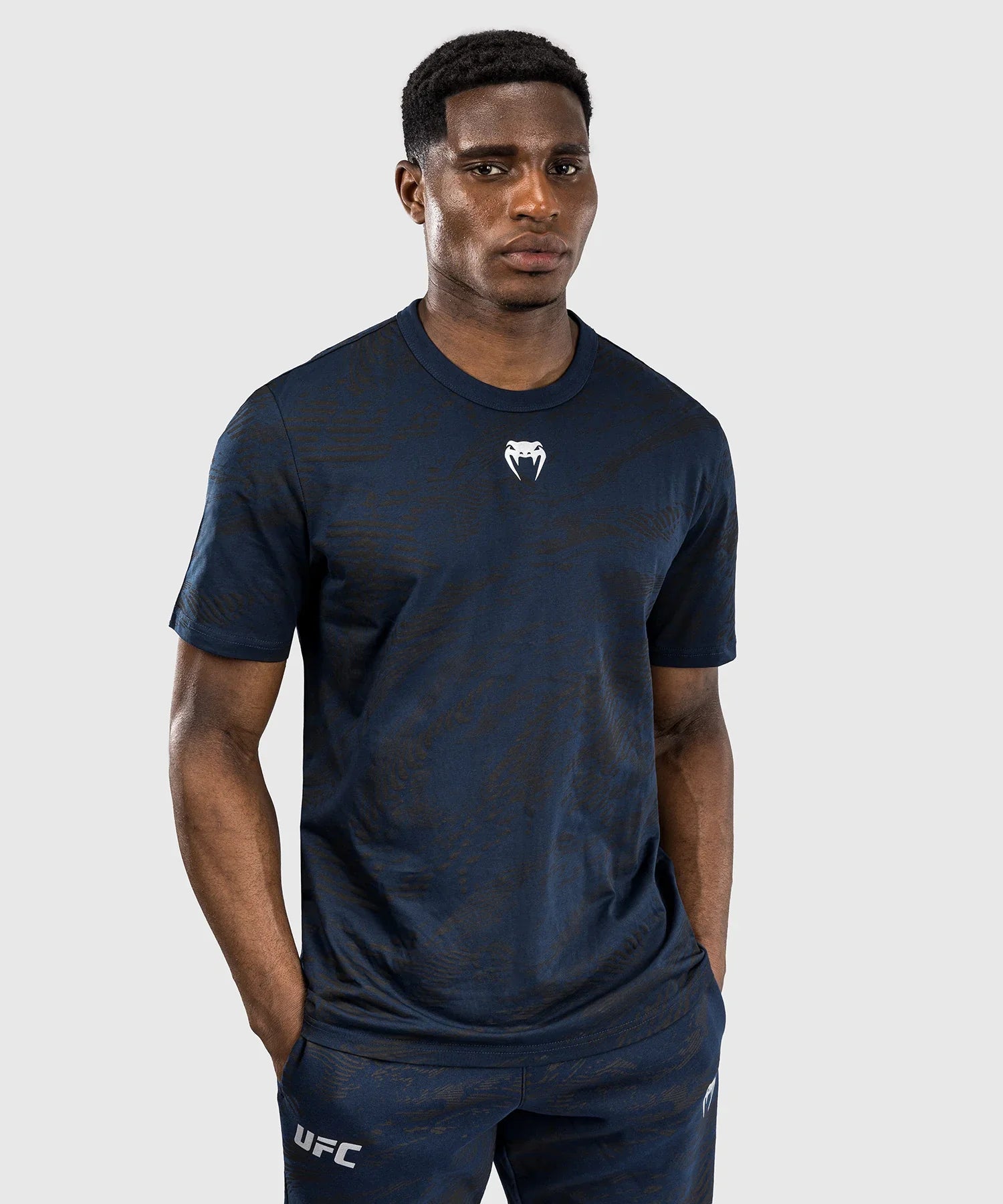 Man wearing navy blue UFC Fusion par Venum cotton T-shirt with short sleeves and round neck, featuring printed Venum logo on chest.