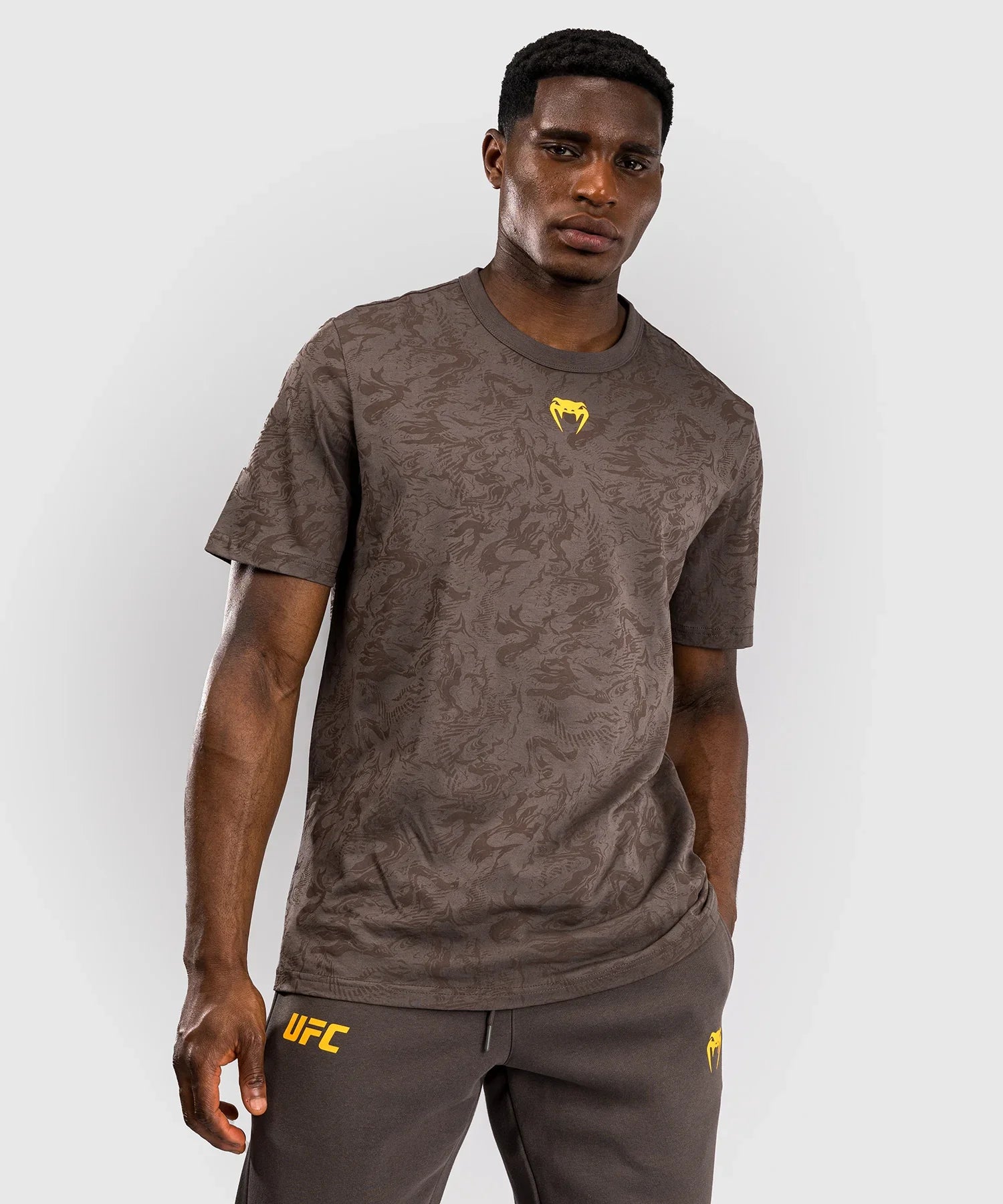 Men wearing brown UFC Fusion par Venum short sleeve cotton T-shirt with subtle pattern and yellow logos.