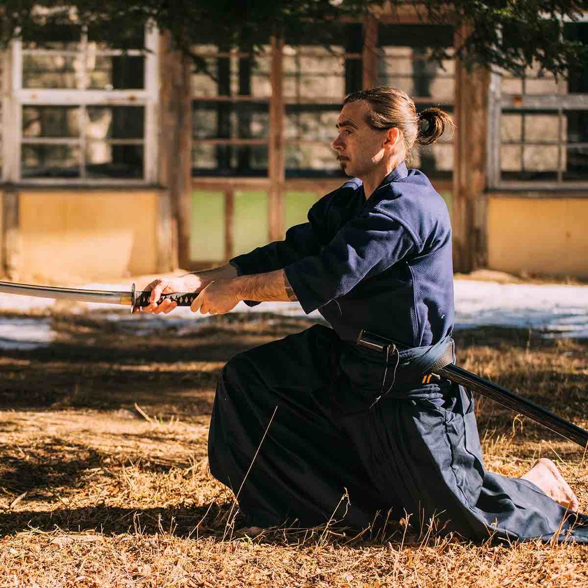 Man practicing Kendo wearing blue FUJIMAE Veste de Kendo rice grain fabric jacket outdoors