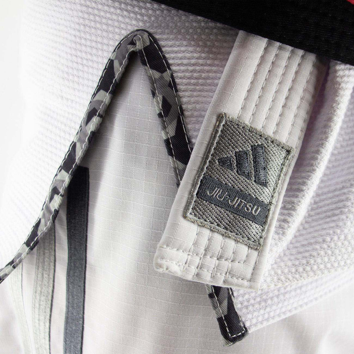 Kimono de JJB Adidas Contest 2.0 blanc avec logo brodé, détail intérieur camo et tissu ripstop renforcé.