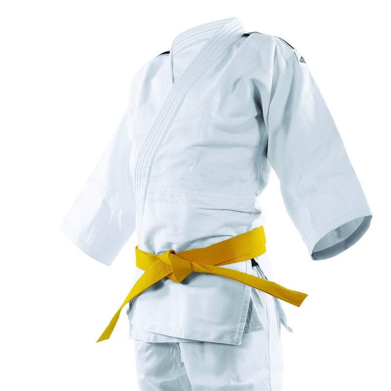 White Adidas judo kimono with black shoulder stripes, 350g/m² rice grain fabric, designed for beginner judokas, shown with a yellow belt.