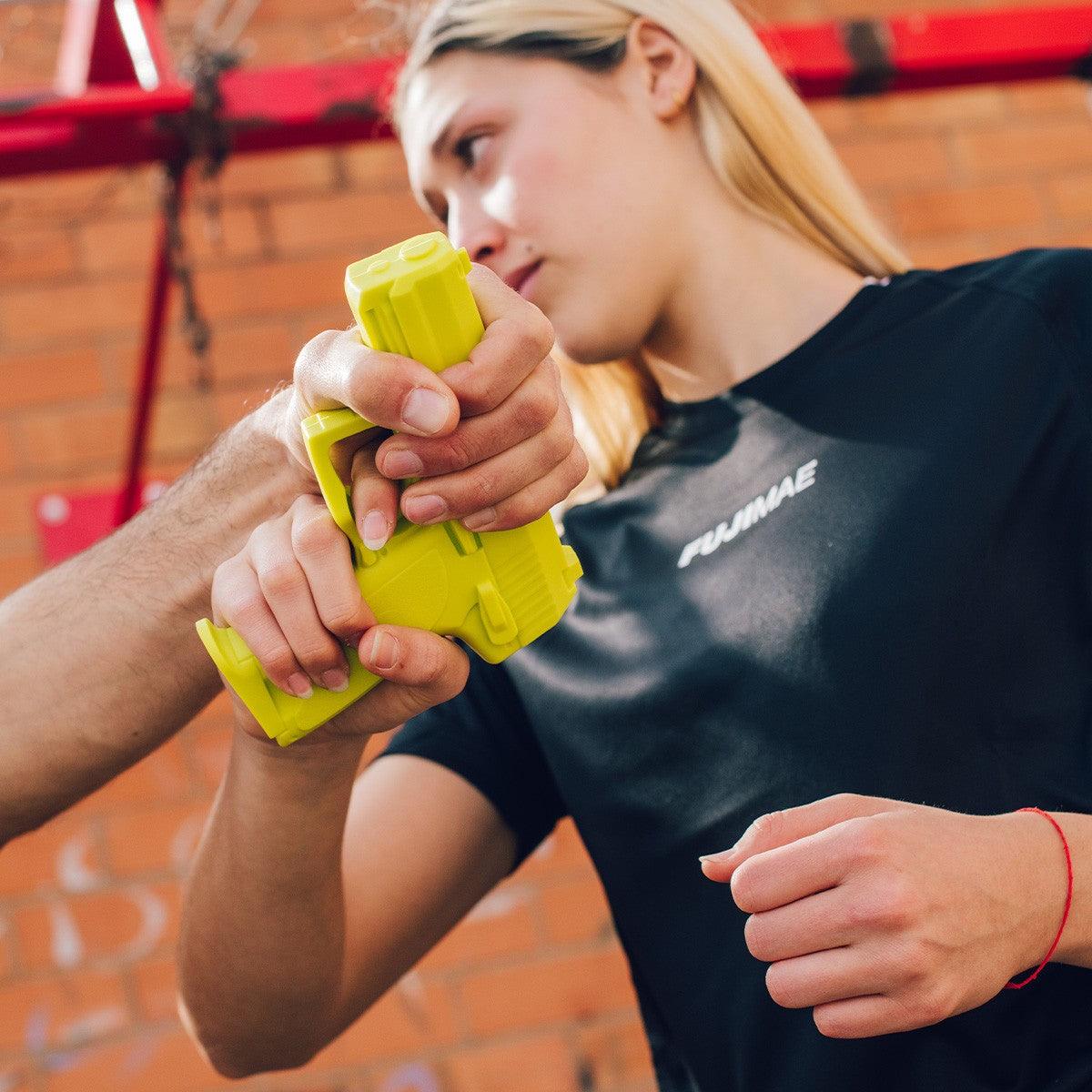 Training with yellow FUJIMAE SD-H93C rubber self-defense pistol by instructor and trainee