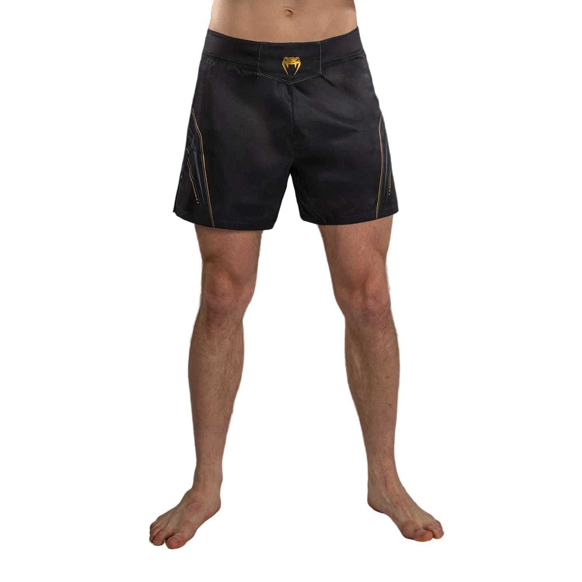 Short de combat noir en polyester, motifs et logo dorés, coupe athlétique avec fentes latérales.