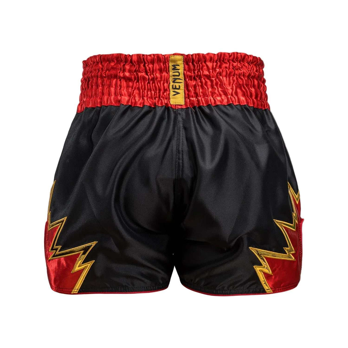 Short de Muay Thai noir en satin, ceinture rouge et motifs éclairs dorés sur les côtés, logo Venum visible