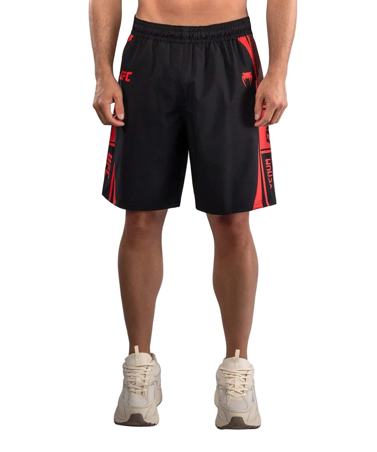 Short d'Entraînement noir en tissu léger, avec ceinture élastiquée, bandes rouges latérales et logos UFC et Venum.