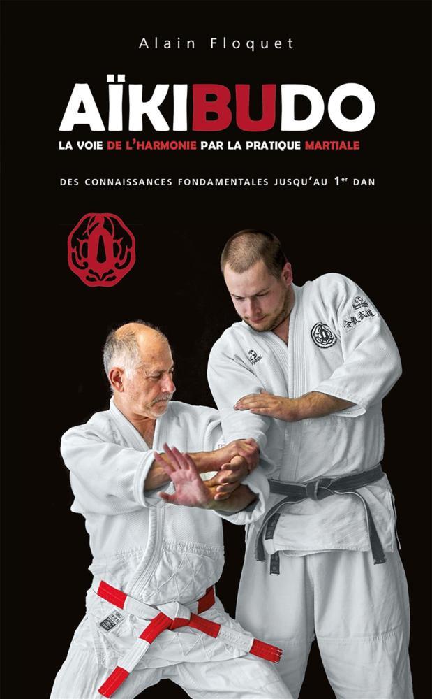 Aïkibudo book cover featuring martial arts master Alain Floquet demonstrating techniques with a student, highlighting fundamental knowledge for black belt practitioners.