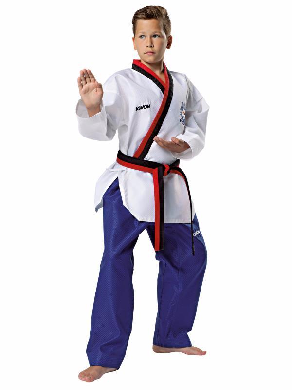Junior male athlete wearing Dobok Poomsae WTF white jacket with red black trim and blue pants performing martial arts pose