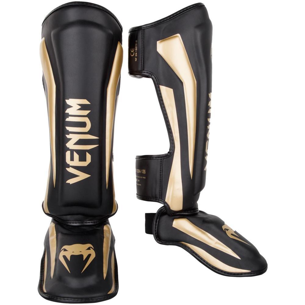 Black and gold Venum Elite shin guards with premium Skintex leather and multi-density foam padding for Muay Thai and kickboxing protection