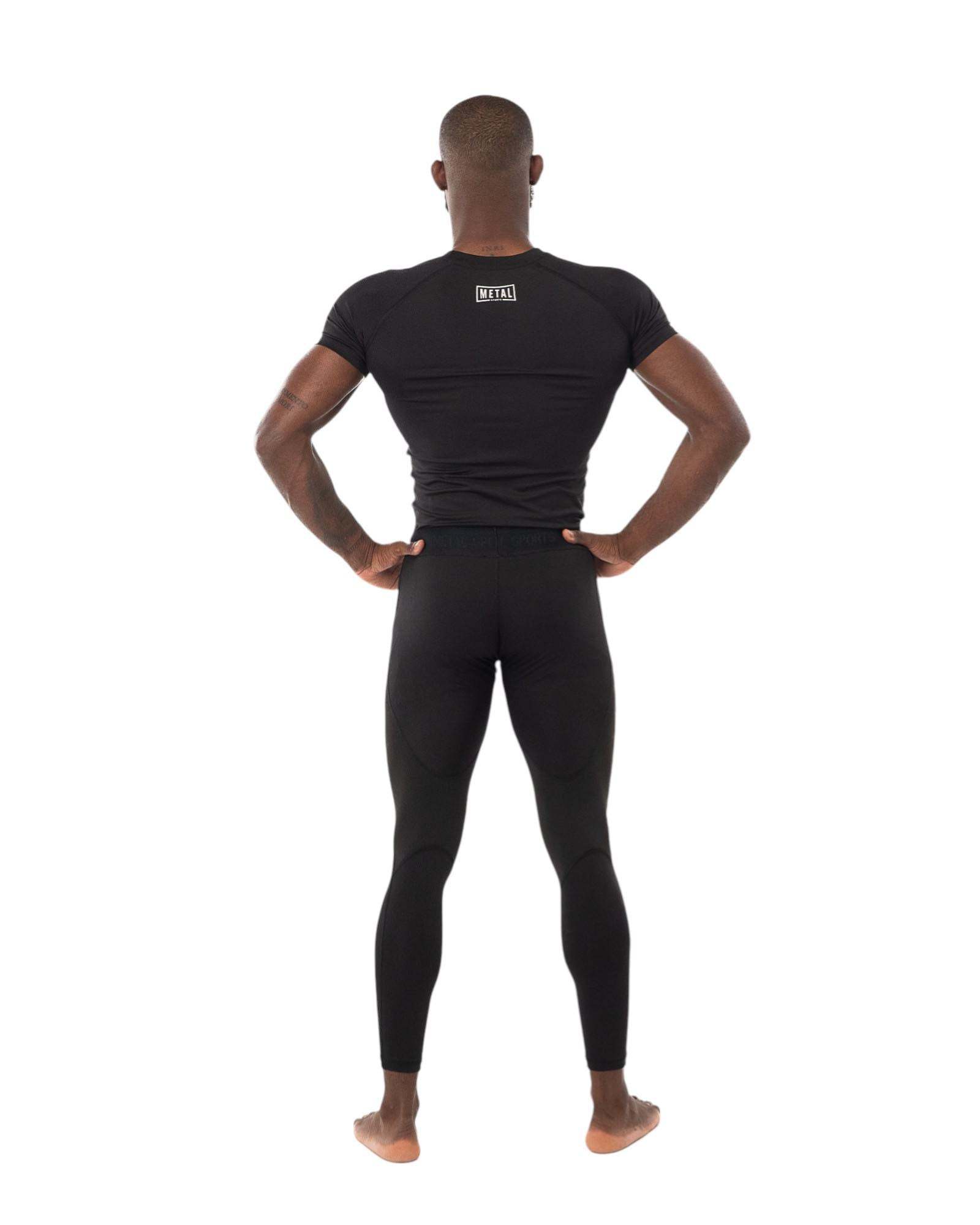 Homme vu de dos portant un rashguard noir ajusté Rashguard One Metal Boxe pour entraînement MMA et sports de combat