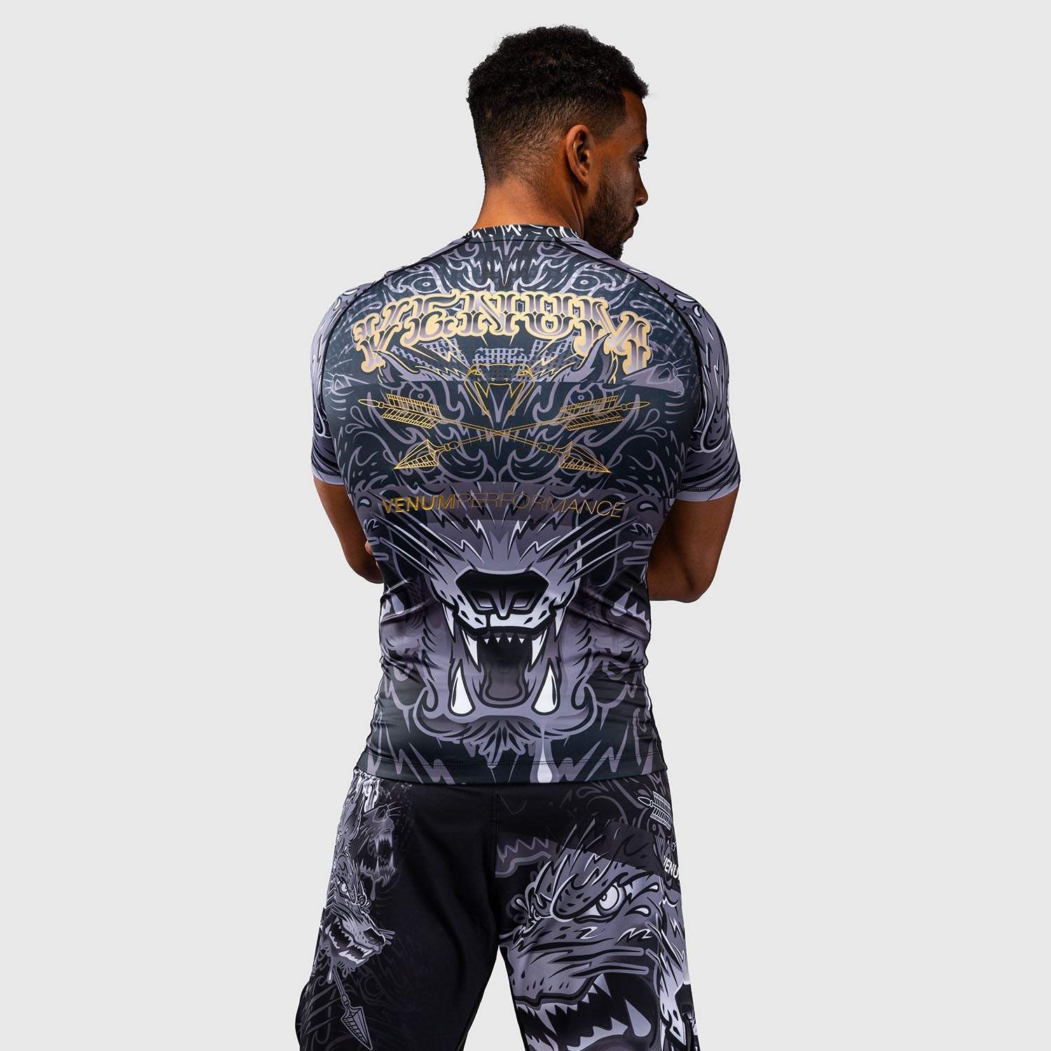 Rashguard manches courtes Venum Wolf Atak noir gris pour sports de combat, compression et respirabilité optimale.