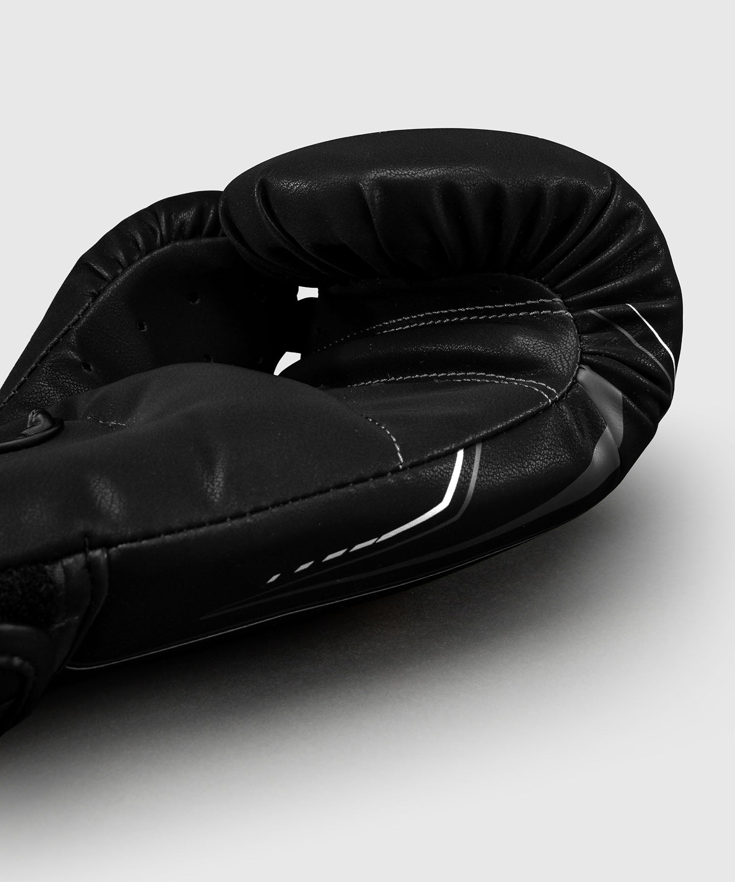 Detail des gants de boxe Venum Streamline noir et blanc, logo Venum et surpiqures