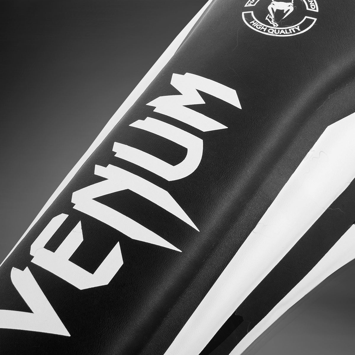 Protège-tibias Venum Elite coloris Noir/Blanc pour le MMA