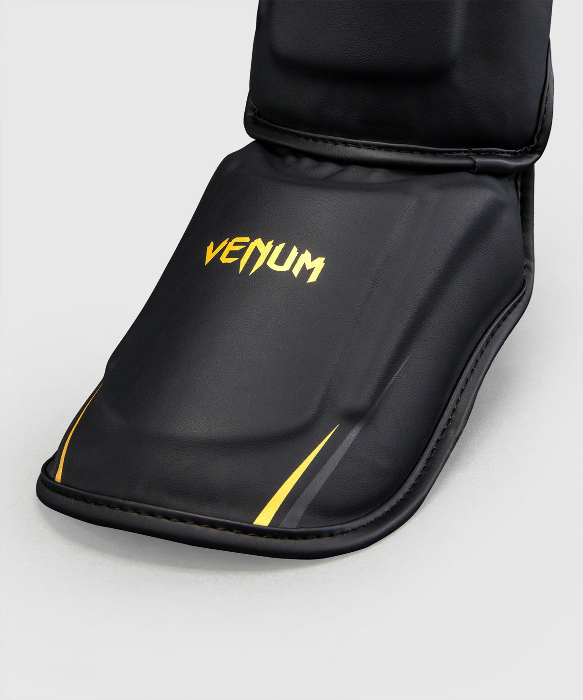 Protège-tibias Venum G-Core Noir/Or disponible à la Boutique des Arts Martiaux