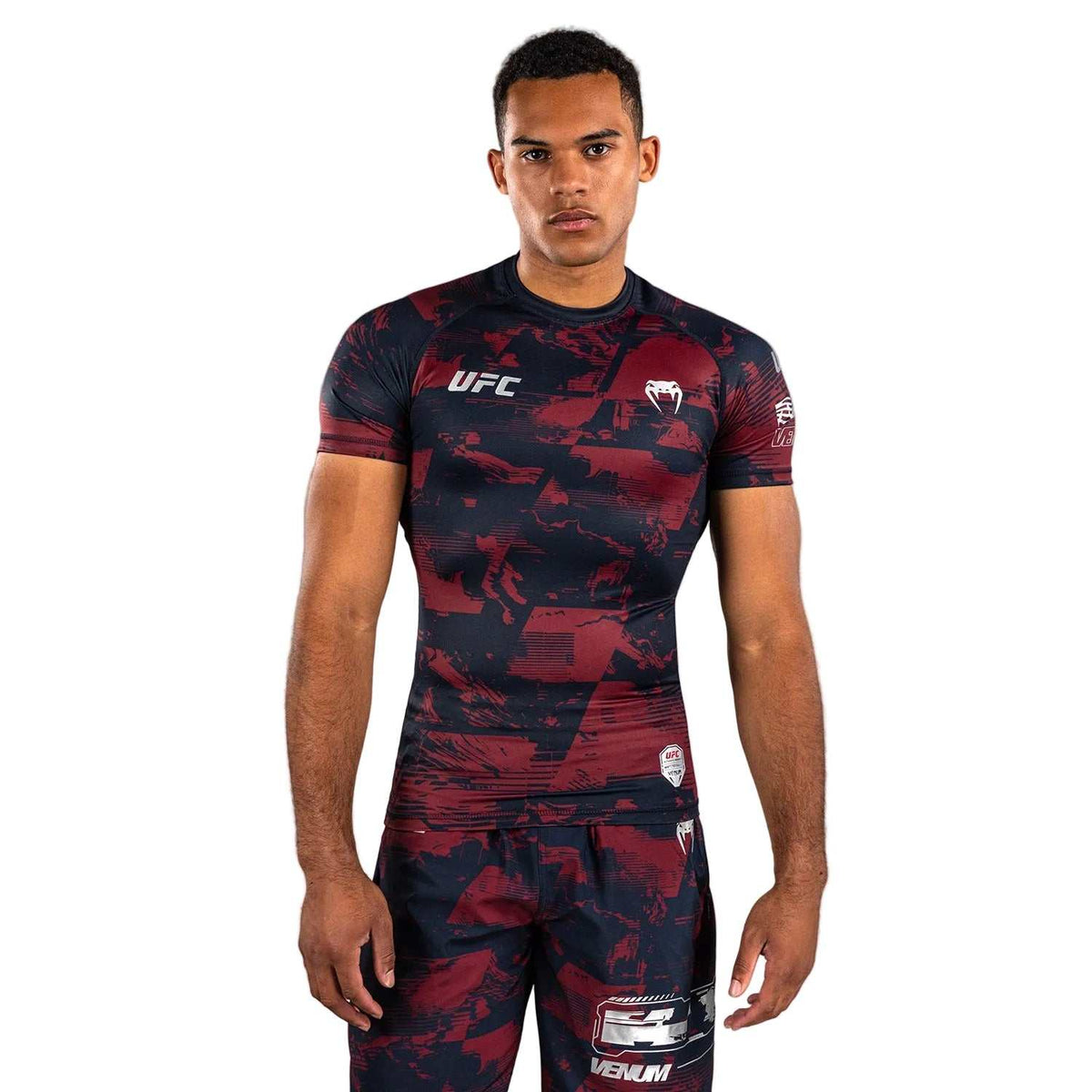Rashguard MC Performance à manches courtes bleu marine et bordeaux, motif graphique et logos argentés, coupe compression.