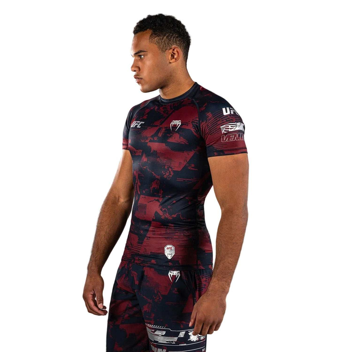 Rashguard MC Performance à manches courtes bleu marine et bordeaux, motifs graphiques rouges et logos argentés en compression