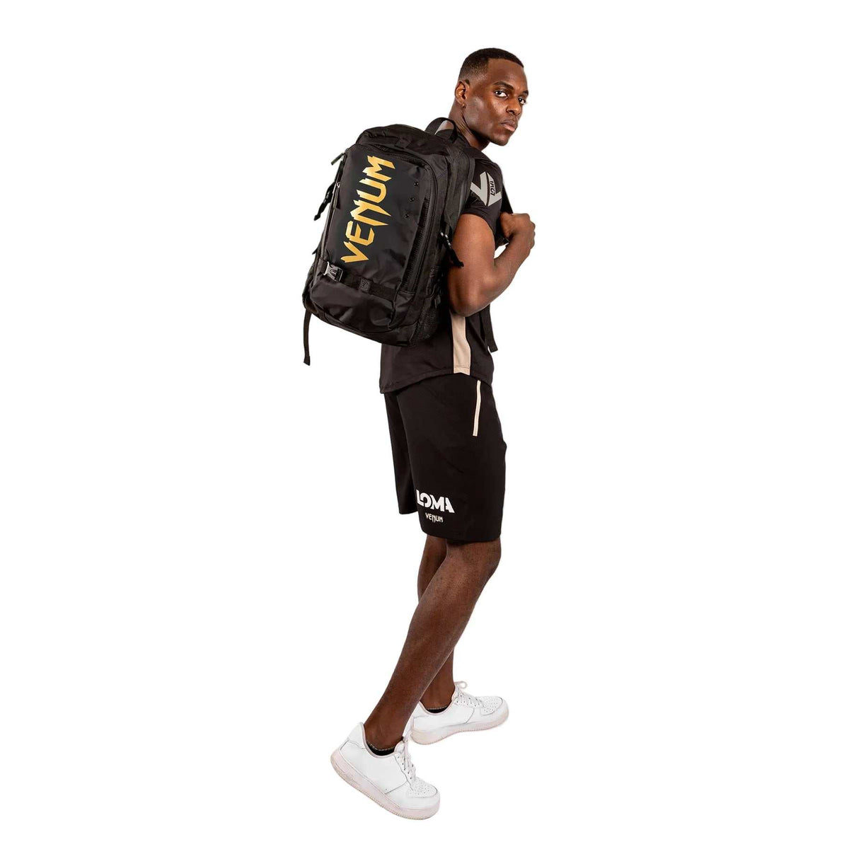 Sac à dos Venum noir en textile, avec logo doré visible, bretelles rembourrées et fermeture zippée.