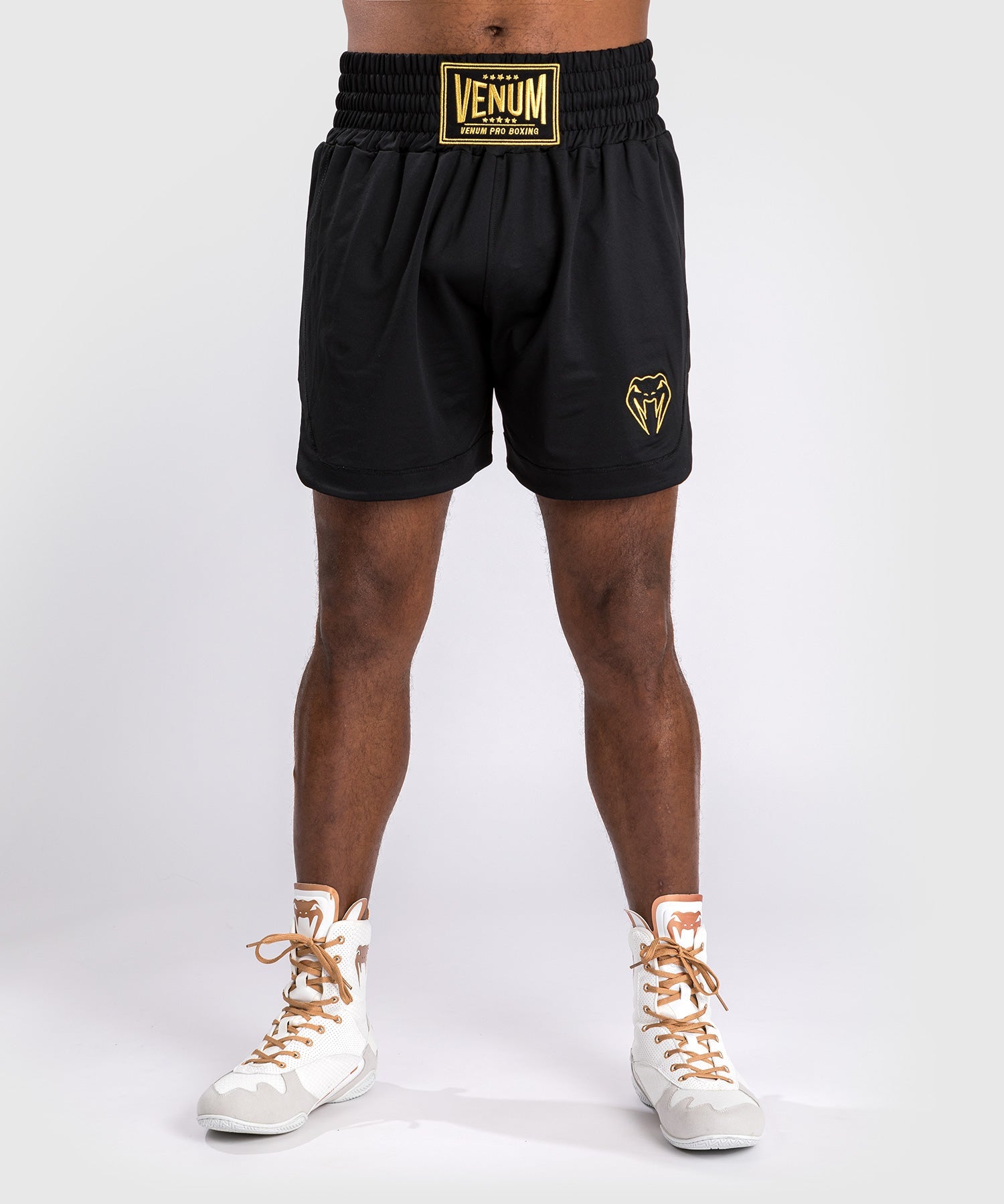 Short de boxe Venum Classic noir et or porte sur le ring