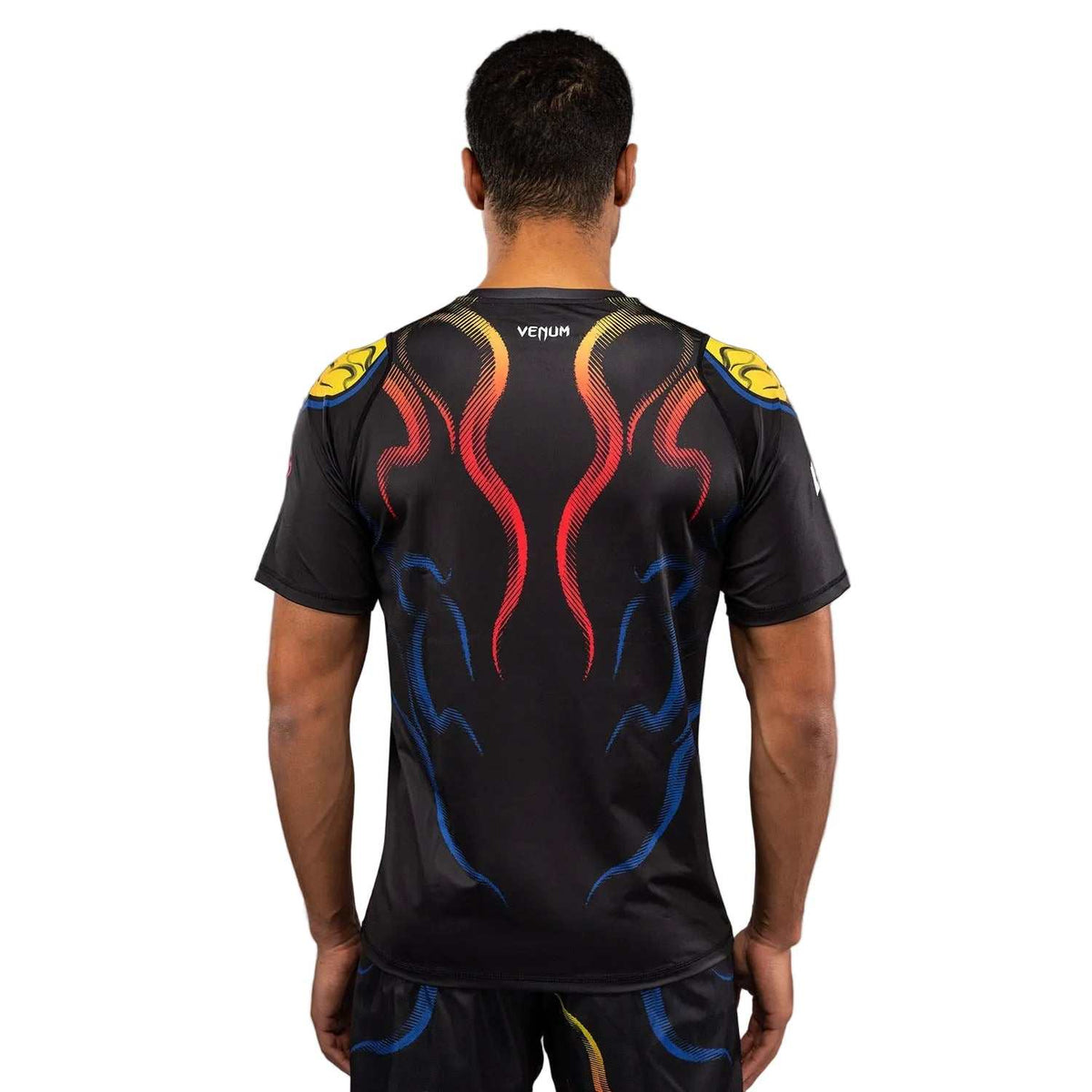 T-shirt Venum noir en tissu technique, dos orné de motifs graphiques rouges, bleus et jaunes.