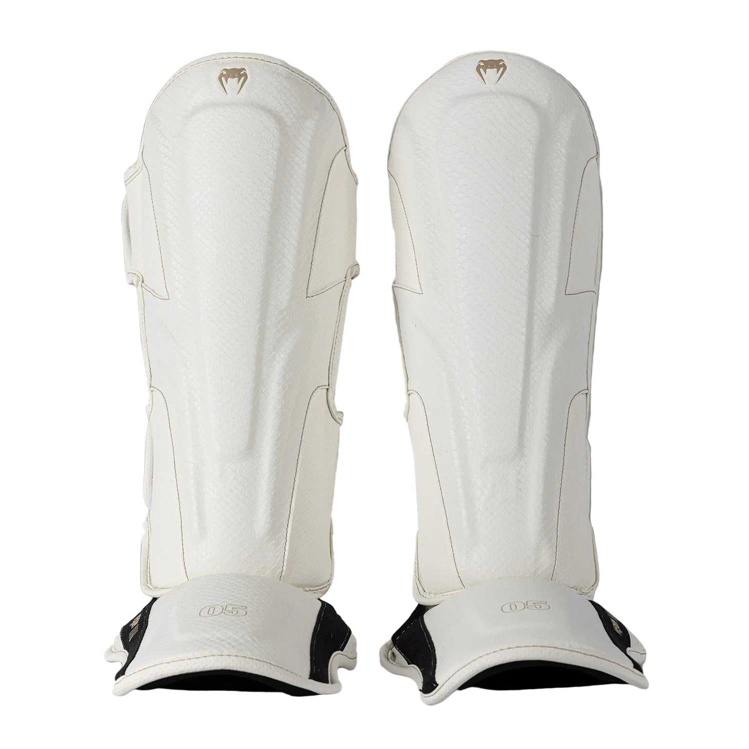 Protège-tibias Venum Impact Evo Scales ivoire en cuir Skintex pour boxe thaï, kickboxing et MMA, mousse multi-densités et maintien velcro sécurisé.