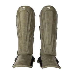 Protège-tibias Venum Impact Evo Scales vert armée avec mousse multi-densités et cuir Skintex premium pour Muay Thaï, kickboxing et MMA